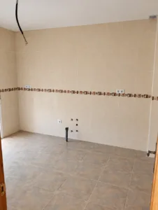 Cocina sin amueblar con azulejos beige y suelo cerámico en vivienda de La Paca