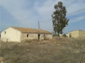 Antigua vivienda rural y construcción auxiliar en un terreno seco de Purias, Lorca