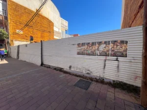 Solar urbano vallado entre edificios y junto a una acera en La Viña, Lorca
